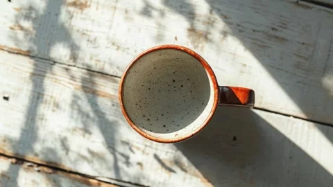 Empty Ceramic Mug Casting Shadow on Rustic Wooden Table Stock Footage 288829782