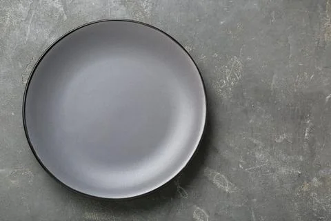Empty ceramic plate on grey table, top view. Space for text Stock Photos