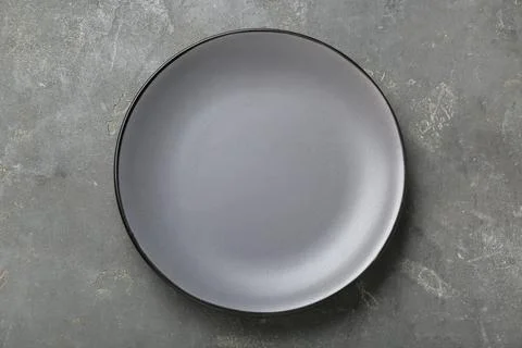 Empty ceramic plate on grey table, top view Stock Photos