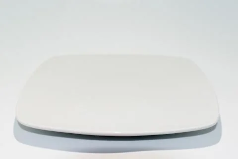Empty ceramic plate isolated on white background. Square dish Stock Photos