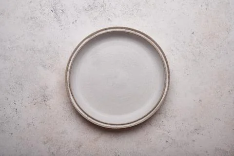 Empty ceramic plate on light concrete table background. Copy space. Menu recipe Stock Photos
