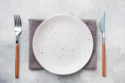 Empty ceramic plate on a light concrete background. Top view. Foto stock