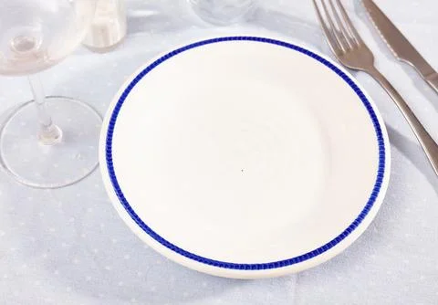 Empty ceramic plate with silverware on table Stock Photos
