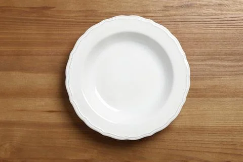 Empty ceramic plate on wooden table, top view Stock Photos