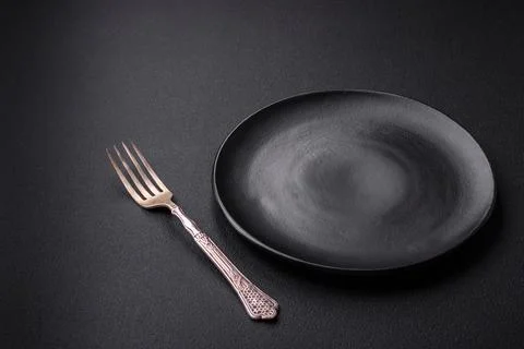 Empty ceramic round plate on dark textured concrete background Stock Photos