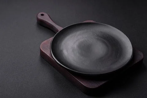 Empty ceramic round plate on dark textured concrete background Stock Photos