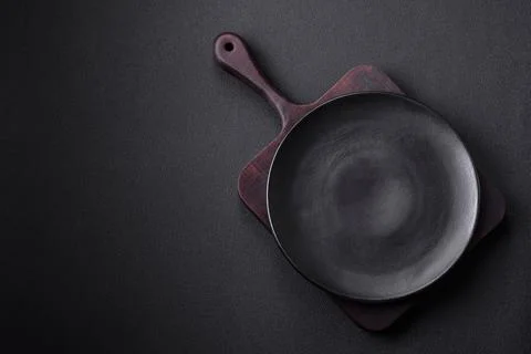 Empty ceramic round plate on dark textured concrete background Stock Photos