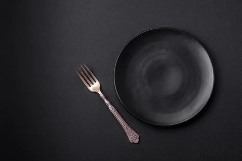 Empty ceramic round plate on dark textured concrete background Stock Photos