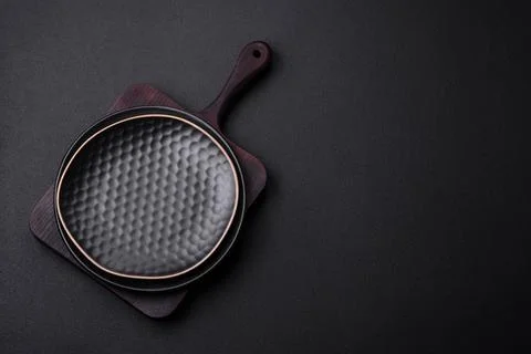 Empty ceramic round plate on dark textured concrete background Stock Photos