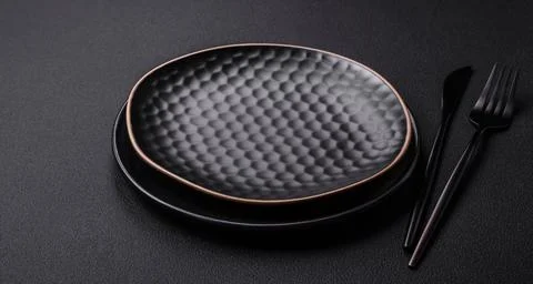 Empty ceramic round plate on dark textured concrete background Stock Photos