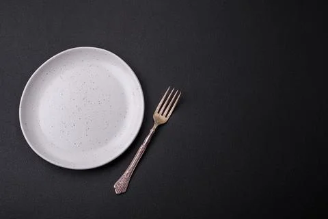 Empty ceramic round plate on dark textured concrete background Stock Photos