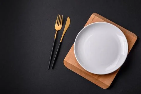 Empty ceramic round plate on dark textured concrete background Stock Photos