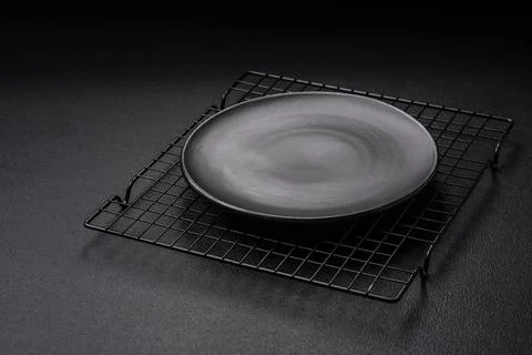Empty ceramic round plate on dark textured concrete background Stock Photos