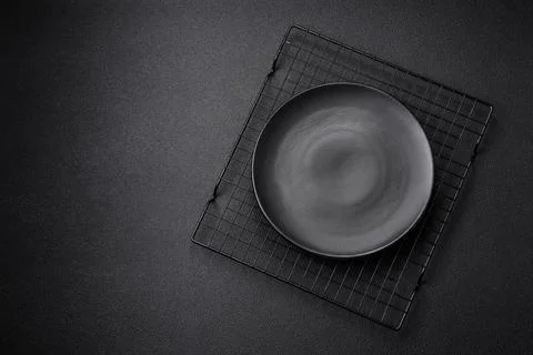 Empty ceramic round plate on dark textured concrete background Stock Photos