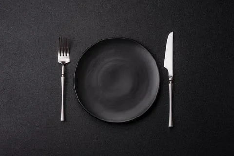 An empty ceramic round plate, kitchen utensils for a dinner table. An empty.. Stock Photos