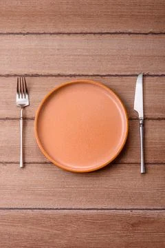 An empty ceramic round plate, kitchen utensils for a dinner table. An empty.. Stock Photos