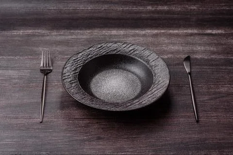An empty ceramic round plate, kitchen utensils for a dinner table. An empty.. Stock Photos