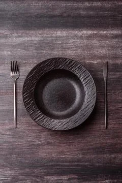 An empty ceramic round plate, kitchen utensils for a dinner table. An empty.. Stock Photos