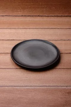An empty ceramic round plate, kitchen utensils for a dinner table. An empty.. Stock Photos