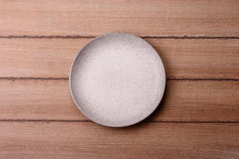 An empty ceramic round plate, kitchen utensils for a dinner table. An empty.. Stock Photos
