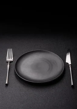 An empty ceramic round plate, kitchen utensils for a dinner table. An empty.. Stock Photos