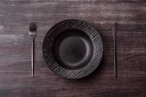An empty ceramic round plate, kitchen utensils for a dinner table. An empty.. Stock Photos