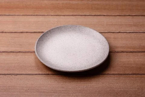 An empty ceramic round plate, kitchen utensils for a dinner table. An empty.. Stock Photos