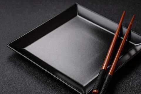An empty ceramic square black plate with chopsticks for Asian food. An empt.. Stock Photos