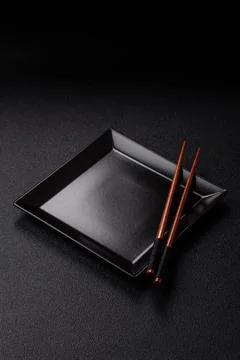 An empty ceramic square black plate with chopsticks for Asian food. An empt.. Stock Photos