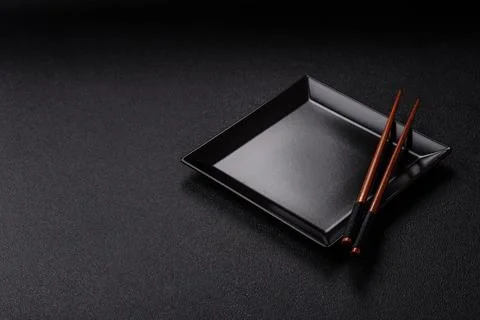 An empty ceramic square black plate with chopsticks for Asian food. An empt.. Stock Photos