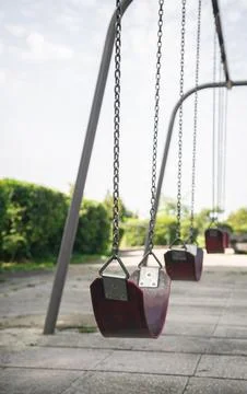 Empty chain swing in the park on a blurred background, close up. Stock Photos