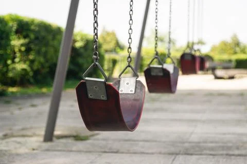 Empty chain swing in the park on a blurred background, close up. Stock Photos
