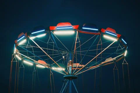 Empty chain swing ride lit with bright LED lights during evening twilight. .. Stock Photos