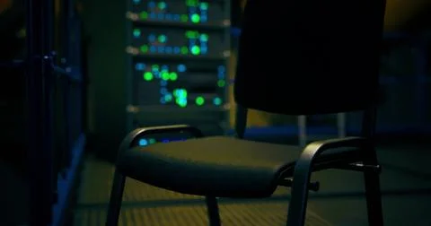 Empty chair in a server room with glowing lights at night Illustrazione stock
