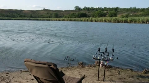 Empty chair waits for angler to come and enjoy carp fishing. Near rod pod, bite Video stock 159774355