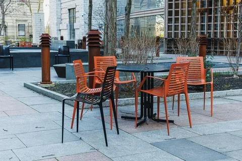 Empty chairs and table at an outdoor area in a city park during a sunny day Foto stock