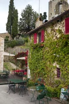 Empty chairs and table on sidewalk cafe by house with ivy plants, Chianti, Stock Photos