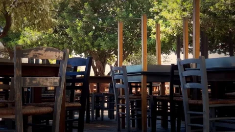 Empty chairs and tables are waiting in an outdoor, small restaurant Vídeo Stock 283498149