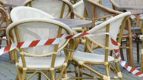 Empty chairs and tables of a cafe , barrier tape, coronavirus , closed, Breme Stock Footage 154448568