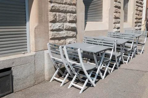 Empty chairs and tables in front of a restaurant Stock Photos