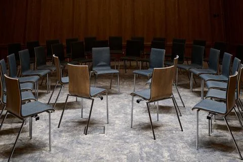 Empty chairs arranged in a large circle for a meeting or group discussion in  Stock Photos