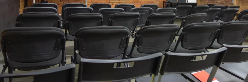 Empty chairs rows in front of white board and wall display before presentatio Stock-Fotos