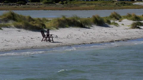 Empty chairs on sandy beach overlooking the ocean Stock Footage 343857547