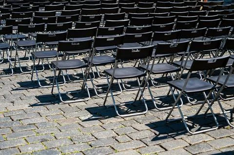 Empty chairs set up for a gathering in a square in Prague under clear skies Stock Photos