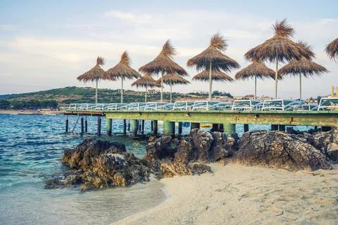 Empty chairs under thatched umbrellas on the beach in albania Stock Photos