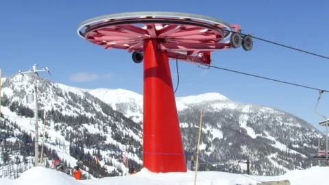 Empty chairs without passengers looping around red chairlift terminal, Canada Stock Footage 129116407