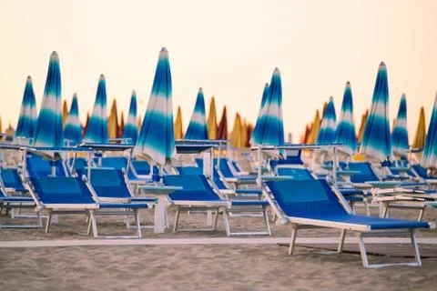Empty chaise-longue with beach umbrellas Stock Photos