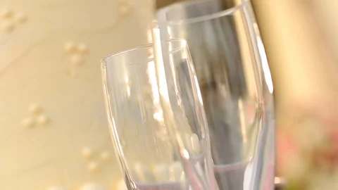 Empty champagne glasses in front of elegant vanilla cake Stock Footage 120407160
