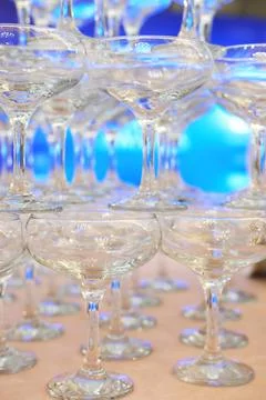 Empty champagne glasses in pyramid or tower on table at wedding reception, .. Stock Photos