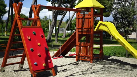 Empty children playground in park with swing swinging on wind 스톡 동영상 275828538